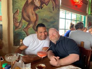 Kris leans on shoulder of friend Nelson Jonson at a restaurant.