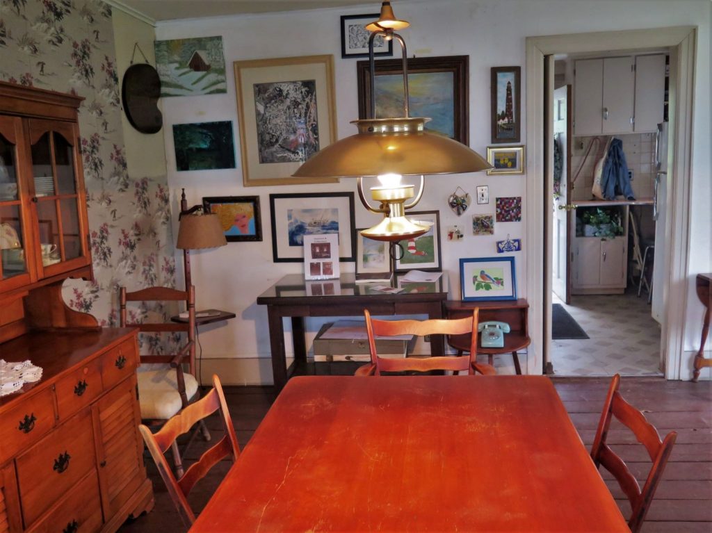 Photo of the dining room of Rutan-Becket House with table, chairs, paintings and rotary phone